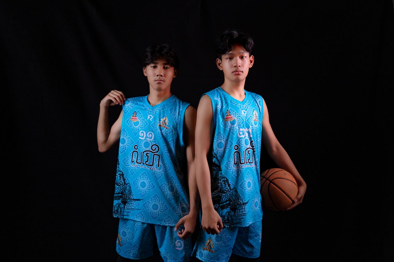Services Studio photo of young Asian men in blue basketball uniforms holding a ball, showcasing team spirit.